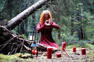 The red-haired witch holds a ritual with a crystal ball