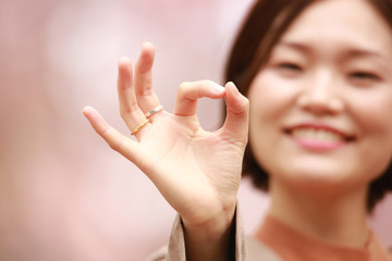 手で丸をつくる女性