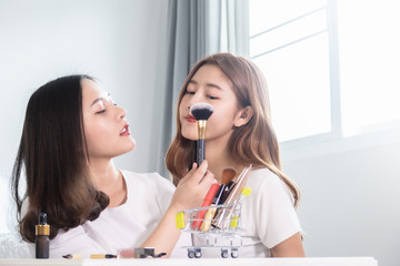 Portrait of young asian woman review giveaway gift product fan following channel, recording video make up lipstic cosmetic at home. Beauty blogger present beauty cosmetics