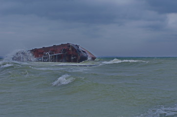 industrial ship wreck on a city beach. shipwreck on the beach.