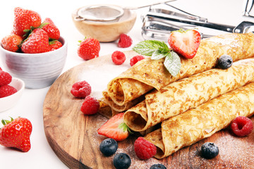 Delicious Tasty Homemade crepes or pancakes with raspberries and mint on rustic background