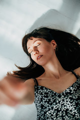 beautiful brunette woman lying on the floor of her apartment to relax