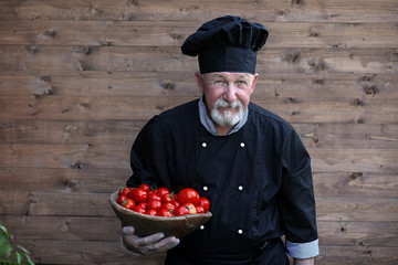 Chef old in uniform with fresh vegetables