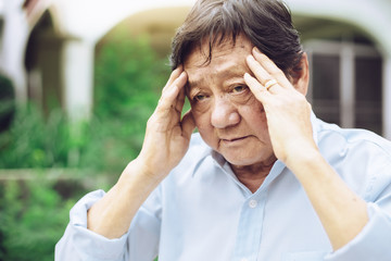 Portrait of an elderly man with headache.senior man covering his face with his hands.vintage tone..