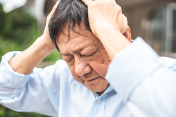 Portrait of an elderly man with headache.senior man covering his face with his hands.vintage tone..