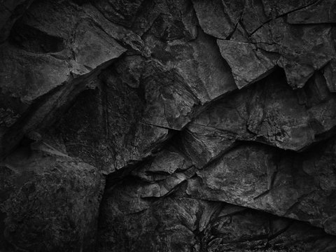 Black grunge texture. Dark gray stone background. Black rock texture. Fragment of a mountain close-up. Abstract geometric gray black white pattern background. Black stone backdrop.