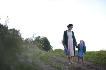 Mother with daughter walking on a road