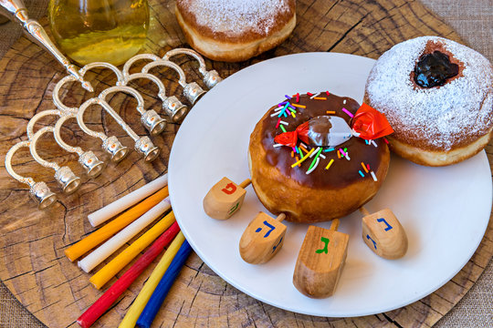 Festive Donut, Menorah, Candles, Jar Of Olive Oil, Dreidels - Traditional Symbols Of Hanukkah Holiday. Hebrew Letters On Four Sides Of Dreidel In English Mean - Great Miracle Happened Here