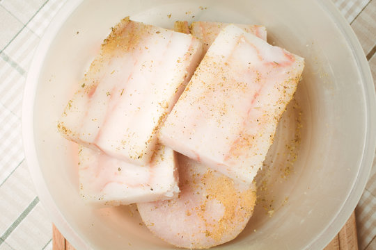 Raw fillet of mintai fish marinated in deep egg pan for cooking.