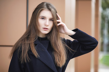 Beautiful girl in a coat in business downtown