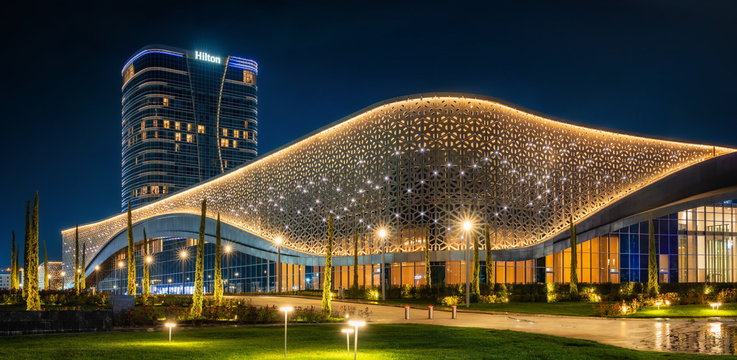Congress hall and Hilton hotel with colorful illumination at night in Tashkent City Park, Uzbekistan