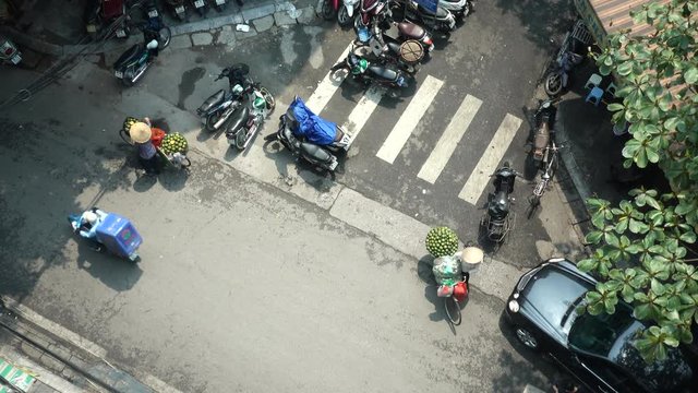 Topshot of Vietnamese Citizens Walking with Hats and Bicycles with Fruit