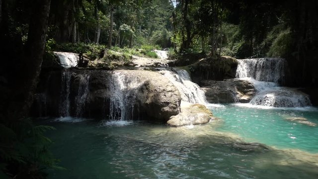 Slowmotion Wideshot Pan of Kuang Si Waterfall with Beautiful Blue Green Water