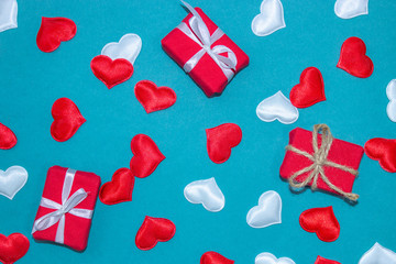 Congratulation on Valentine's Day on a blue background. Background for Valentine's Day with red and white hearts and gifts. Happy Valentines Day. Horizontal top view, flat lay.