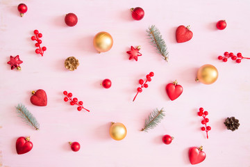 Pink wooden christmas background with red and gold color christmas decorations. View from above