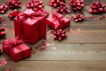 Red gift box with bows, on wooden background. Copy space. Valentine's day, birthday, Christmas.