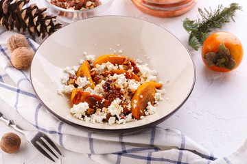 Winter dessert. caramelized persimmon with walnuts and cottage cheese