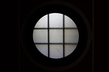 circle porthole window with high contrast between the light and the dark background