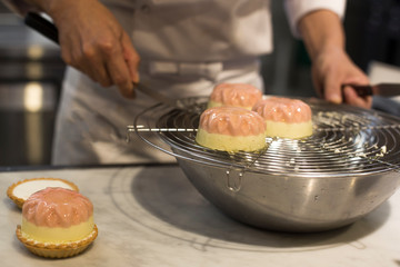 Decorating pink mini cake on the table. Sweets and desserts.