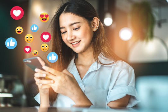 Asian woman in a cafe drinking coffee .Young woman watching a live stream.