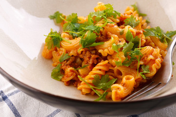 traditional pasta with meat and herbs in a beige plate