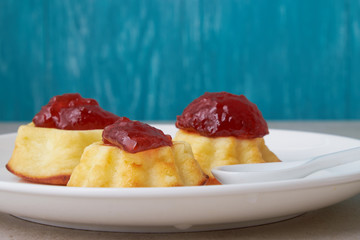 A portion of cottage cheese casserole with strawberry jam and peaches