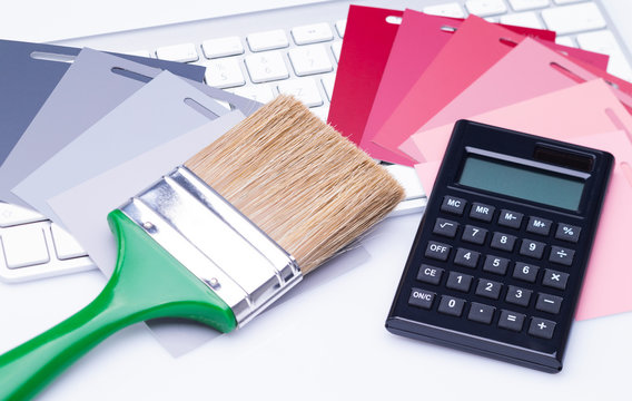Brush with calculator and color cards on keyboard
