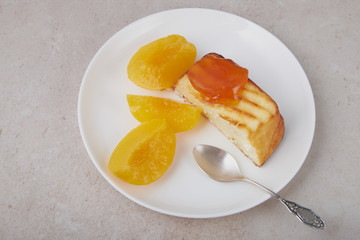 A portion of cottage cheese casserole with strawberry jam and peaches