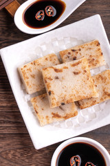 Delicious turnip cake, Chinese traditional radish cake in restaurant with soy sauce for new year's dishes, close up, copy space, top view, flat lay.