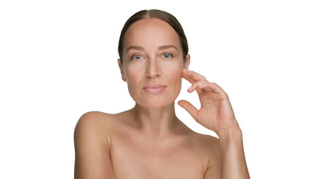 Close-up beauty portrait of young woman with smooth healthy skin, she gently touches her face with her fingers on white background