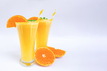 Orange smoothies yellow colorful fruit juice milkshake blend beverage healthy high protein the taste yummy In glass,drink to lose weight drink episode morning on white gray background.
