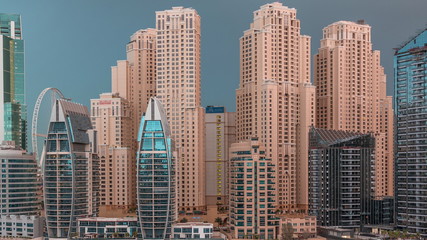 Fototapeta na wymiar Luxury yachts parked on the pier in Dubai Marina bay with city aerial view night to day timelapse
