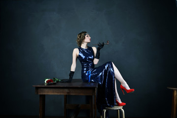 girl in a blue evening dress with a pipe
