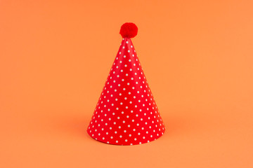 Colorful birthday caps on orange background.