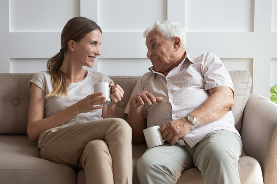 Happy young woman communicating with smiling old father.
