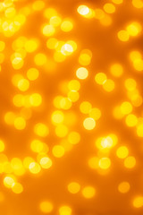 Bokeh background of abstract glitter lights, yellow, orange, gold, de focused.