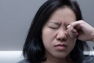 Asian woman rubbing her eye. Concept of  eye's problem, dust allergy, dry eye, watery, itching or...