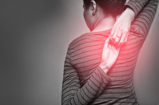 Asian woman exercising for shoulder stretching. Eagle Arms Asana. Posing for shoulder flexibility to relieve symptom of office syndrome. Black and white tone with red spot on woman's back