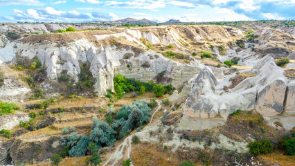 Fototapeta na wymiar Mountain landscape in Pigeon valley in Cappadocia, Turkey. Unreal rock formations of Cappadocia