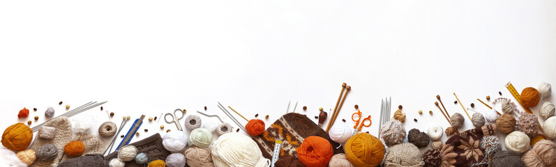 Panoramic view of composition with knitting accessories: balls of wool yarn, knitting needles,...