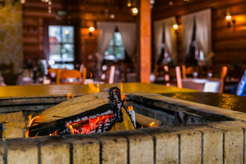 Cosy style restaurant with a stove wood fire burning in fireplace. Hot embers in a bonfire. Closeup