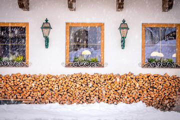 Winter landscape in the city of Neustift in the Stubai Valley in Austria. Windows of a typical Austrian house with firewood in front of the house