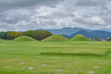 Scenic view of several ancient tombs in traditional korean style village in Gyeongju in South Korea. Beautiful summer cloudy look of few mounds in Republic of Korea. 