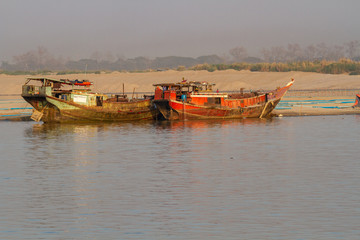 Commercial boats on the banks of the Irrawaddy river, Mandalay, Burma.
