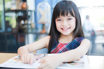 Asian little girl reading book smile and happy face