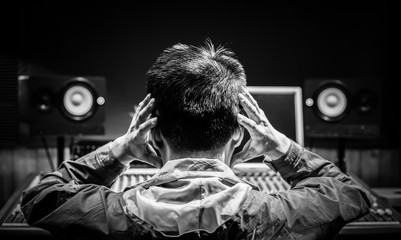 back of asian male music producer feel disappointed at bad sound in recording studio. music...