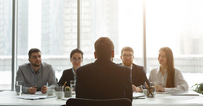 HR manager interviewing man, candidate sitting back to camera