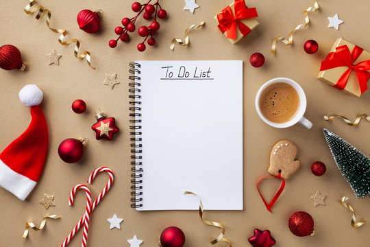 Cup of coffee, holiday decorations and notebook with to do list on golden background top view, Christmas planning concept. Flat lay style.