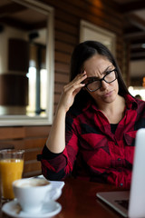 Beautiful Young Woman is working on her laptop in the Cafe