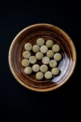 Bio Green BARLEY GRASS tablets. Concept for a healthy dietary supplementation. Black paper background. Close up.